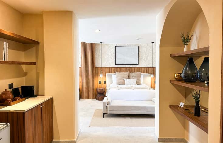 Ana y Jose hotel room, wooden bed, balcony with sea view, warm décor