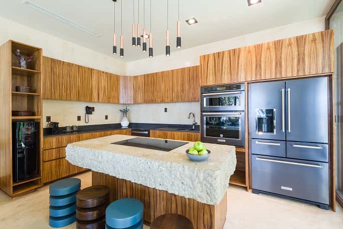 fully equipped kitchen, dining area with wooden table, pendant lights, open concept